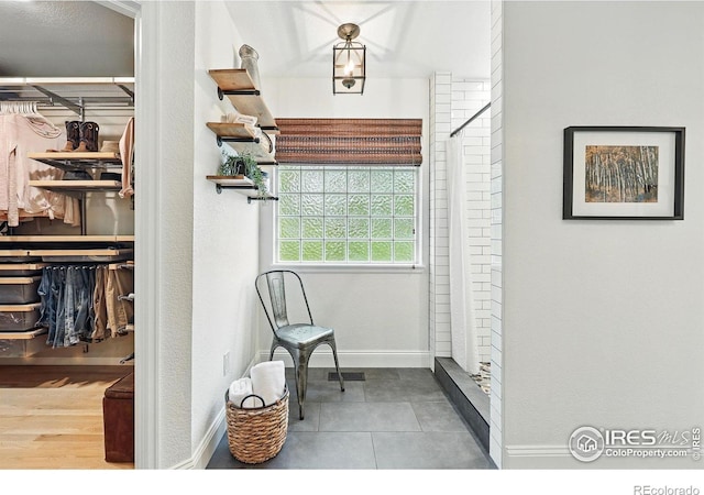 sitting room featuring baseboards, visible vents, and tile patterned floors