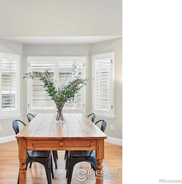 dining space featuring baseboards and light wood-style floors