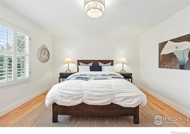 bedroom featuring baseboards and wood finished floors