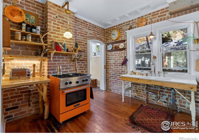 838 University Ave, Boulder, CO 80302 - kitchen with crown molding, stainless steel range, brick wall, and hardwood / wood-style floors