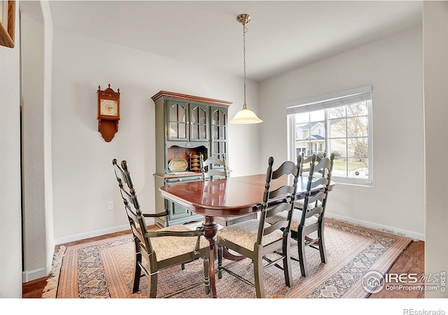 dining room with baseboards and light wood-type flooring