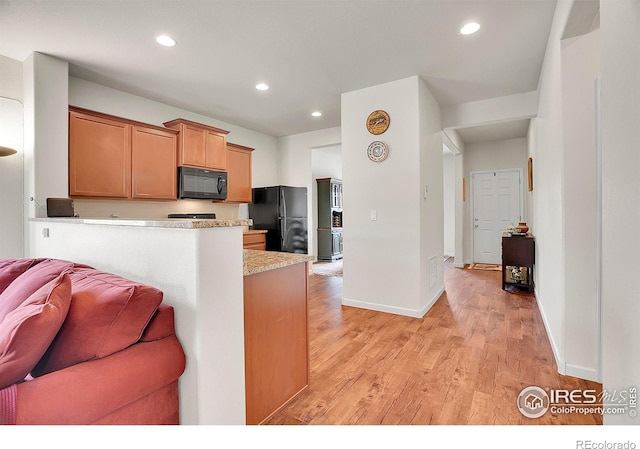 kitchen with light wood-type flooring, open floor plan, black appliances, and recessed lighting