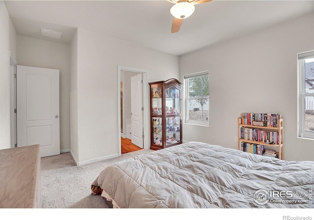 bedroom featuring baseboards, light colored carpet, ceiling fan, and visible vents