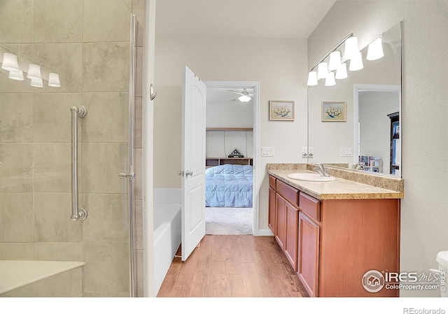 ensuite bathroom with vanity, a shower stall, wood finished floors, and connected bathroom