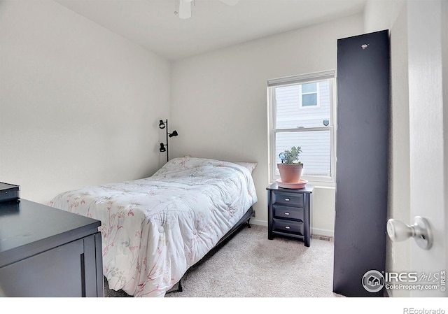 bedroom featuring light colored carpet and baseboards
