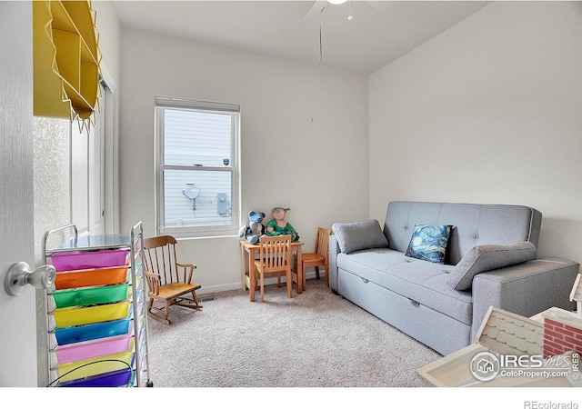 carpeted living area featuring a ceiling fan and baseboards