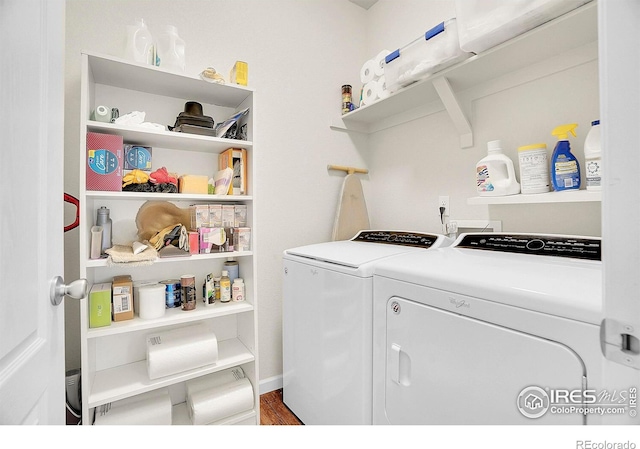 laundry room with laundry area, washing machine and dryer, and wood finished floors