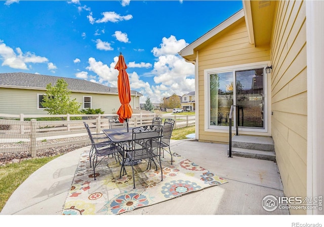 view of patio featuring outdoor dining area and fence