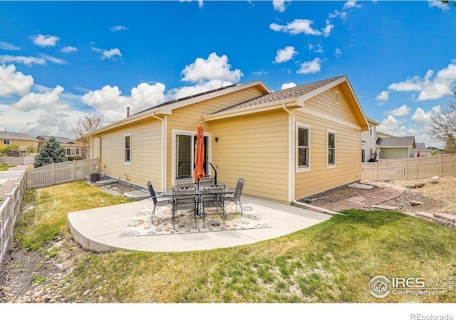 back of house featuring a lawn, a fenced backyard, and a patio area