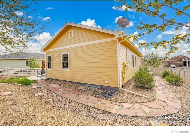 rear view of house featuring a fenced backyard