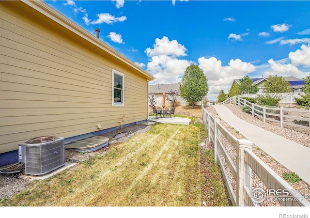 view of yard with a fenced backyard, a patio area, and central AC