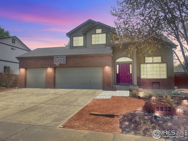 traditional home with brick siding, roof with shingles, and driveway