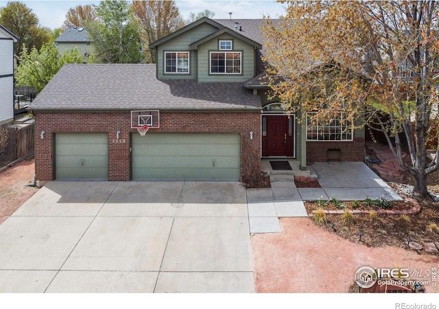 traditional-style house featuring concrete driveway, brick siding, roof with shingles, and a garage