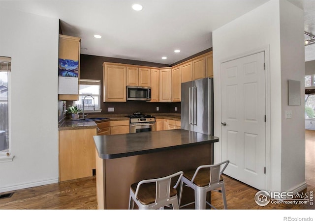 kitchen with a sink, dark wood finished floors, light brown cabinetry, and stainless steel appliances