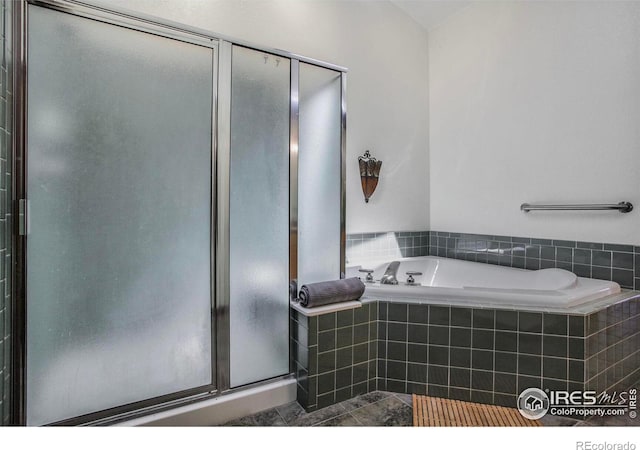 full bathroom featuring tile patterned floors, a garden tub, and a stall shower
