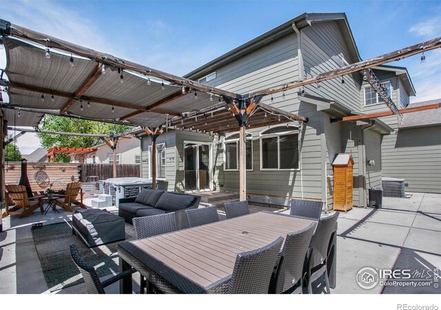 view of patio / terrace featuring fence, outdoor dining space, a hot tub, and an outdoor living space