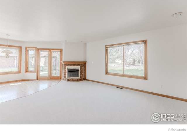 1609 Sherman Way, Longmont, CO 80501 - unfurnished living room featuring baseboards, a fireplace, carpet flooring, and visible vents