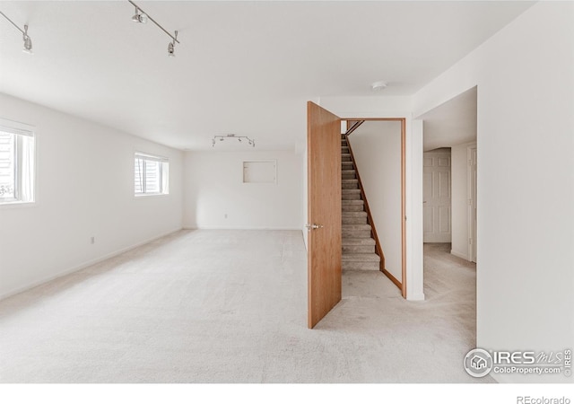 1609 Sherman Way, Longmont, CO 80501 - below grade area with stairs, rail lighting, baseboards, and carpet