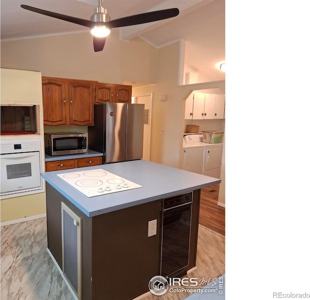 4202 Coronado St, Greeley, CO 80634 - kitchen with ornamental molding, lofted ceiling, ceiling fan, separate washer and dryer, and appliances with stainless steel finishes