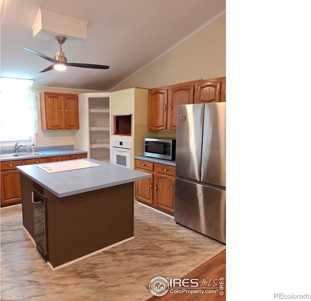 4202 Coronado St, Greeley, CO 80634 - kitchen featuring a ceiling fan, a center island, vaulted ceiling, a sink, and stainless steel appliances
