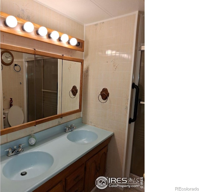 4202 Coronado St, Greeley, CO 80634 - full bath with double vanity, tile walls, a sink, and a stall shower