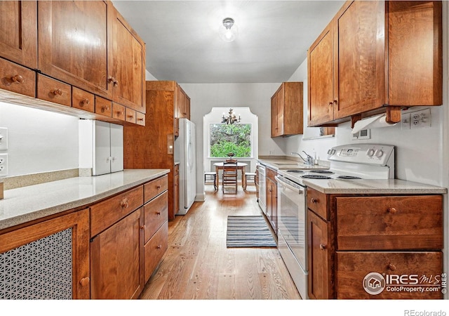 1025 5th St, Boulder, CO 80302 - kitchen featuring a sink, light wood finished floors, white appliances, and brown cabinetry