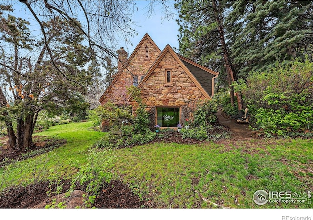1025 5th St, Boulder, CO 80302 - english style home featuring a front yard, a chimney, and stone siding