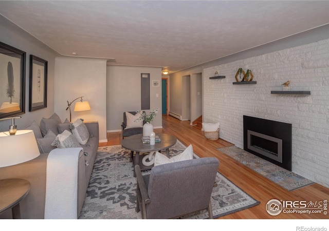 2605 Crabapple Ct, Golden, CO 80401 - living area with baseboards, a baseboard radiator, a fireplace, and wood finished floors