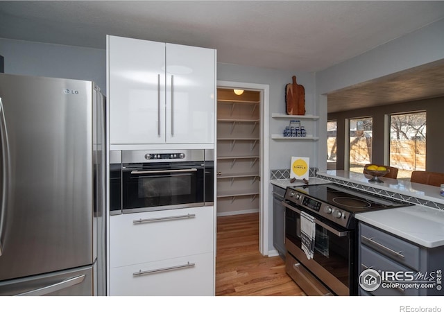2605 Crabapple Ct, Golden, CO 80401 - kitchen with open shelves, light wood-style floors, gray cabinets, white cabinetry, and appliances with stainless steel finishes