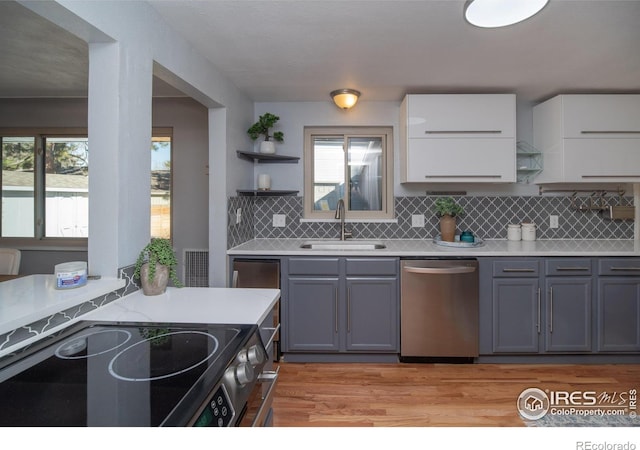 2605 Crabapple Ct, Golden, CO 80401 - kitchen with electric range oven, stainless steel dishwasher, open shelves, a sink, and light countertops