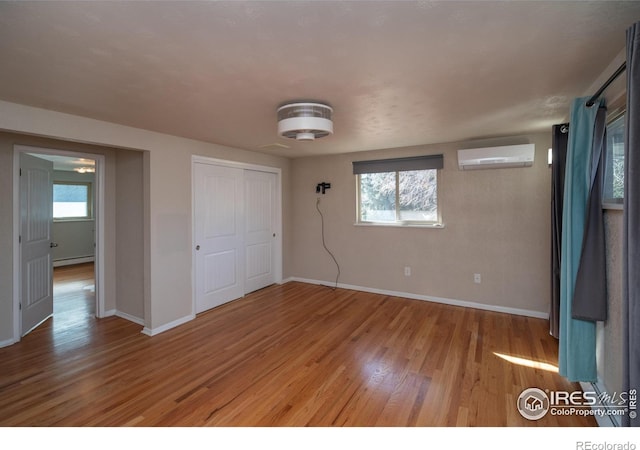 2605 Crabapple Ct, Golden, CO 80401 - unfurnished bedroom featuring baseboard heating, baseboards, a wall unit AC, and wood finished floors