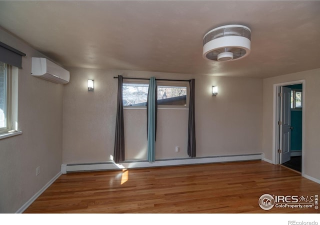 2605 Crabapple Ct, Golden, CO 80401 - unfurnished room featuring a wall mounted AC, wood finished floors, and a wealth of natural light