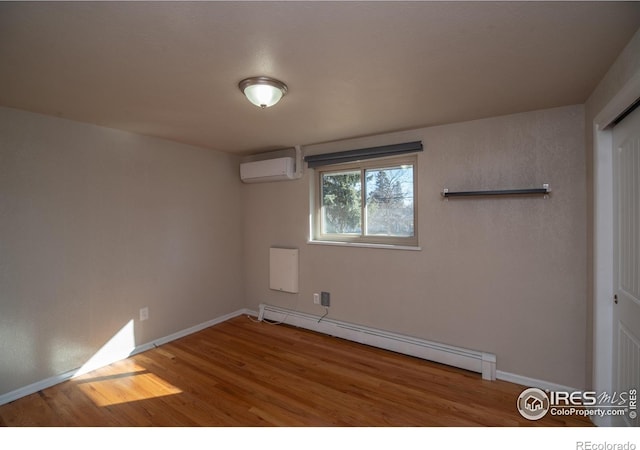 2605 Crabapple Ct, Golden, CO 80401 - unfurnished room with baseboards, a baseboard radiator, a wall unit AC, and wood finished floors