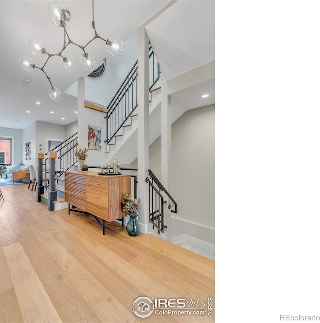 2890 Curtis St, Denver, CO 80205 - stairs with wood finished floors, a chandelier, recessed lighting, a high ceiling, and baseboards