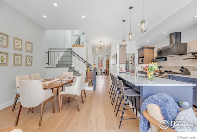 2890 Curtis St, Denver, CO 80205 - dining area featuring stairs, light wood-type flooring, a chandelier, recessed lighting, and baseboards