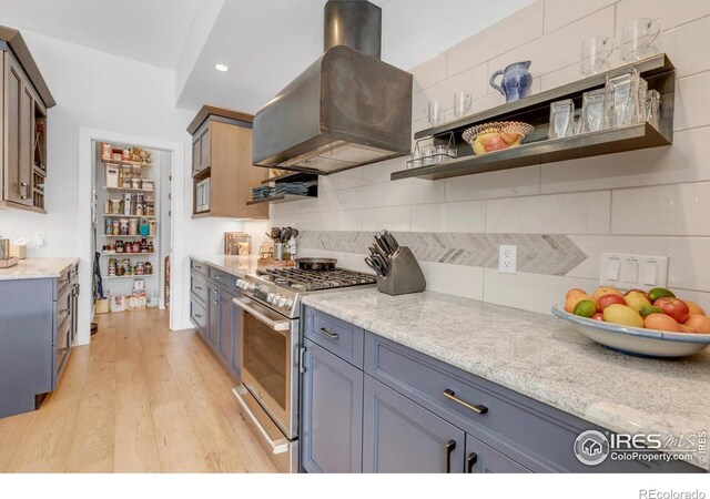 2890 Curtis St, Denver, CO 80205 - kitchen featuring gas range, island range hood, backsplash, light wood-style flooring, and recessed lighting