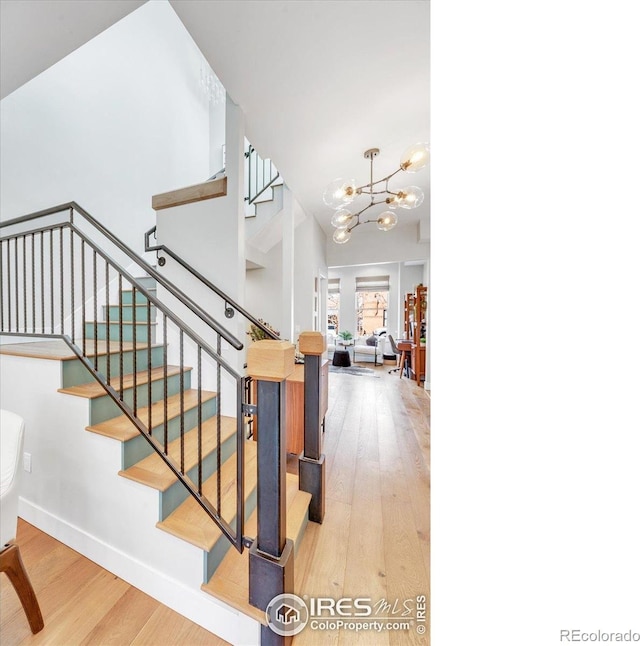 2890 Curtis St, Denver, CO 80205 - stairs featuring wood finished floors, a chandelier, and baseboards