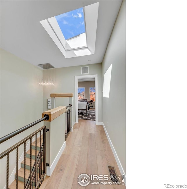 2890 Curtis St, Denver, CO 80205 - hall featuring a skylight, an upstairs landing, and light wood-type flooring