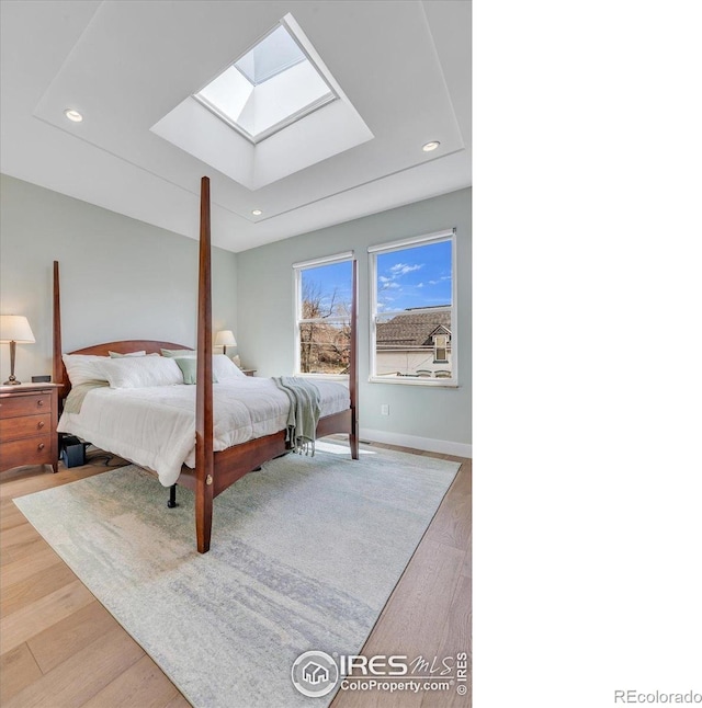 2890 Curtis St, Denver, CO 80205 - bedroom with a skylight, wood finished floors, recessed lighting, and baseboards