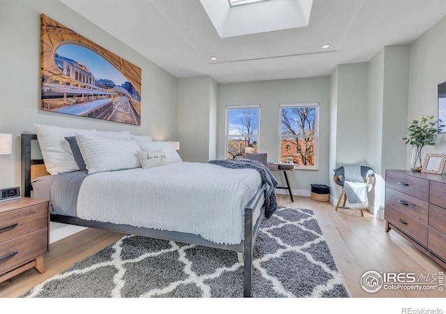 2890 Curtis St, Denver, CO 80205 - bedroom featuring light wood-style floors, a skylight, recessed lighting, and baseboards
