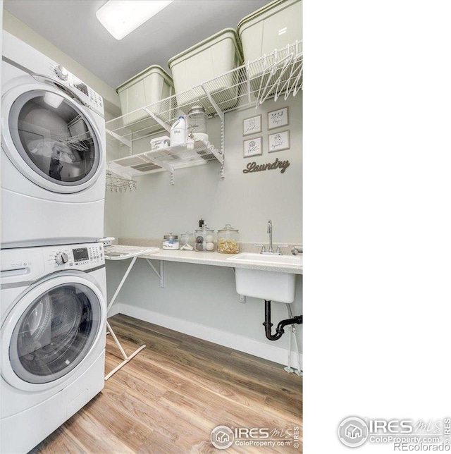2890 Curtis St, Denver, CO 80205 - laundry room with stacked washing machine and dryer, wood finished floors, and baseboards