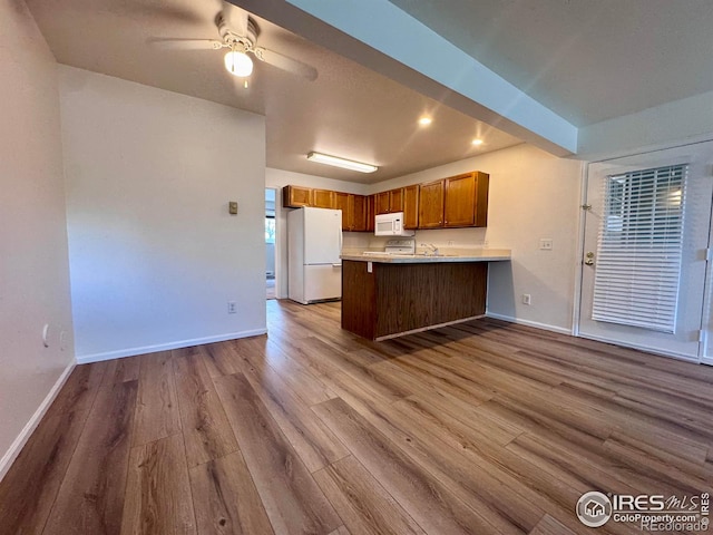 3565 Windmill Dr Unit 3, Fort Collins, CO 80526 - kitchen featuring white appliances, wood finished floors, baseboards, brown cabinetry, and recessed lighting
