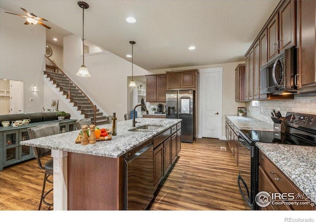 kitchen featuring a sink, wood finished floors, a kitchen bar, and stainless steel appliances