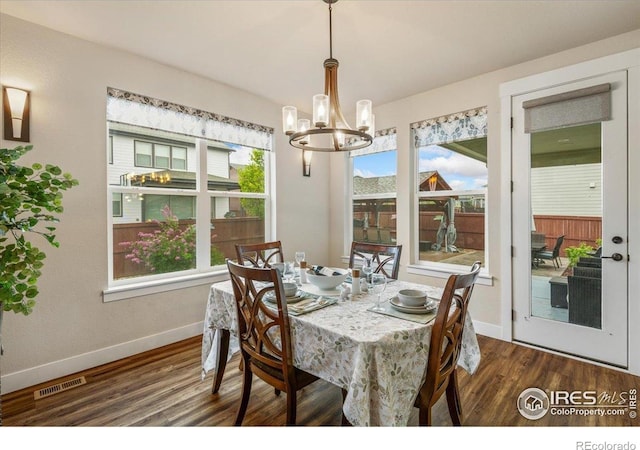 dining room with visible vents, baseboards, dark wood-type flooring, and a chandelier
