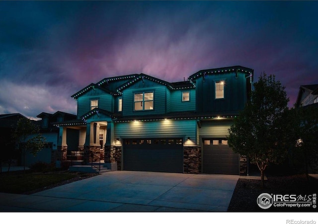 craftsman-style home with an attached garage, board and batten siding, stone siding, and concrete driveway