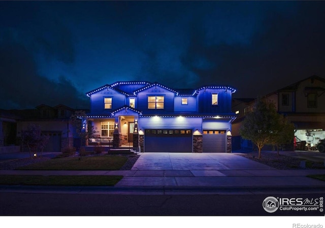 craftsman house with an attached garage, concrete driveway, and stone siding