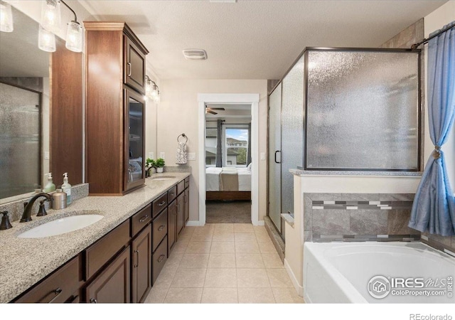 ensuite bathroom with tile patterned floors, a sink, ensuite bathroom, and a garden tub
