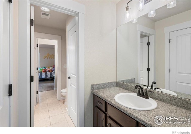 bathroom with toilet, tile patterned floors, visible vents, and vanity