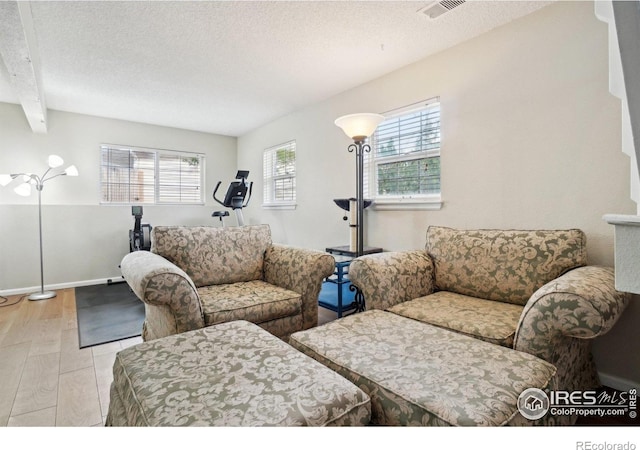 13755 W 65th Dr, Arvada, CO 80004 - living room featuring wood finished floors, a textured ceiling, baseboards, and beam ceiling