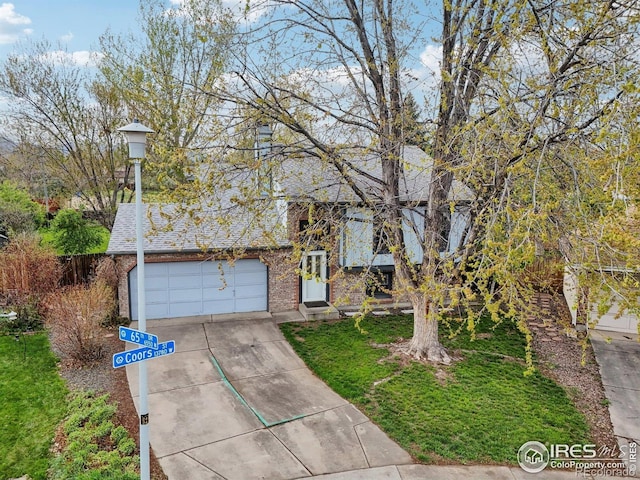 13755 W 65th Dr, Arvada, CO 80004 - view of front of house with concrete driveway, a garage, brick siding, and a front yard